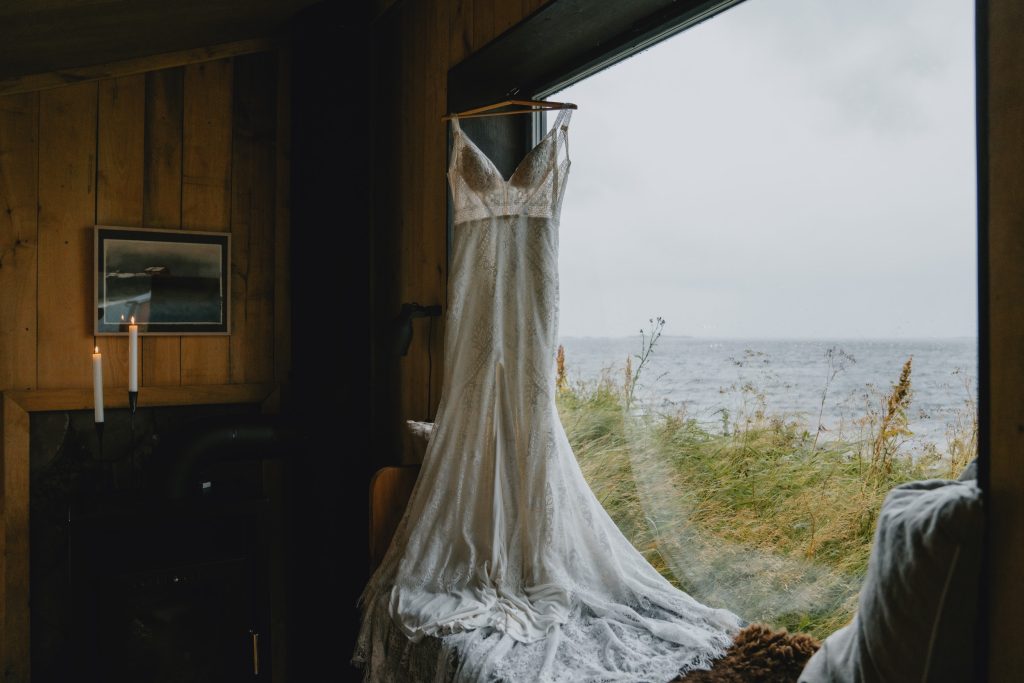 Moody Norway elopement on Senja Island. Weddingdress hanging. By Christin Eide Photography