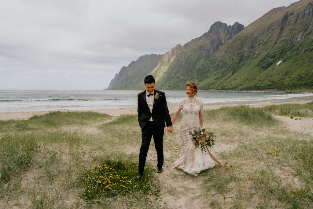 How to choose your elopement photographer. Strolling along the beach on their elopement day in Senja, Norway. By Christin Eide Photography