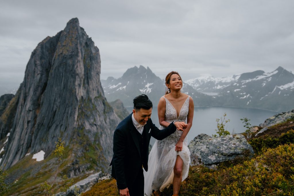 How to choose your elopement photographer. Hiking Hesten on Senja overlooking Segla on their elopement day. By Christin Eide Photography